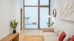 A modern living room with a sofa, a wooden bench, and a potted plant. - Flats - Poeta Serrano (Valencia)