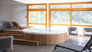 A spa area with a hot tub, wooden steps, and seating. - Apartment in Serre Chevalier Ski Resort (VAUJANY)