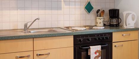 Een koelkast, een oven, een kookplaat, een koffiezetapparaat/waterkoker
