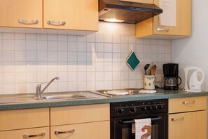 Een koelkast, een oven, een kookplaat, een koffiezetapparaat/waterkoker