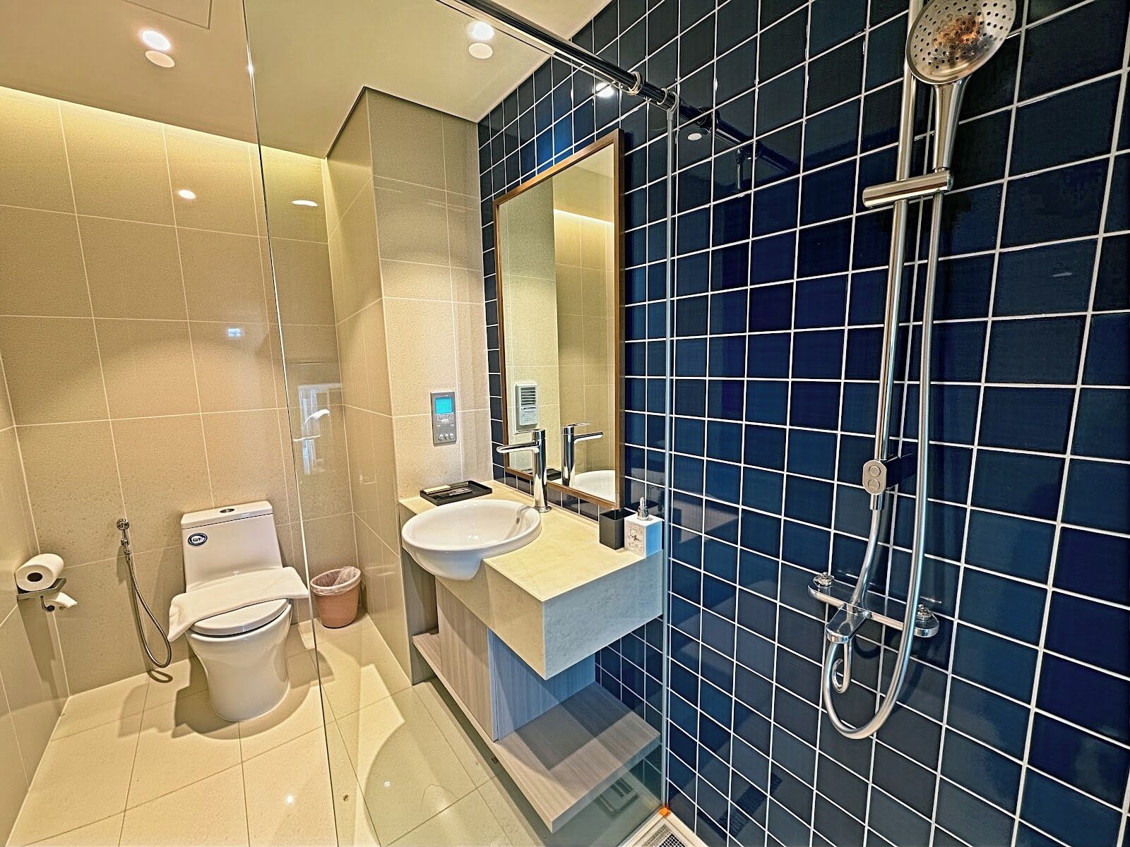 A modern bathroom with a toilet, sink, and shower.