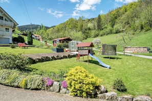Un barrio residencial con césped, un parque infantil y casas.