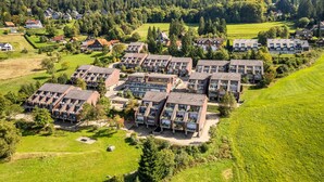 A residential area with multiple apartment buildings, green lawns, and trees.