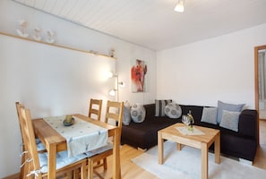 Une pièce comprenant une table à manger, des chaises, un canapé et une table basse.
