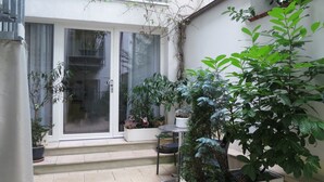 A patio area with potted plants, a table, and a chair. - Holiday Apartment 'K3ab, 60sqm' with Balcony and Wi-Fi (Konstanz)