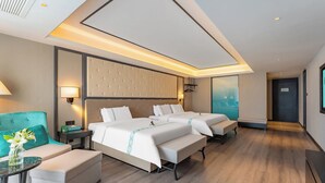 A modern hotel room with a large bed, a sofa, a small table, and a nightstand. - xana Hotel  (Qionghai)