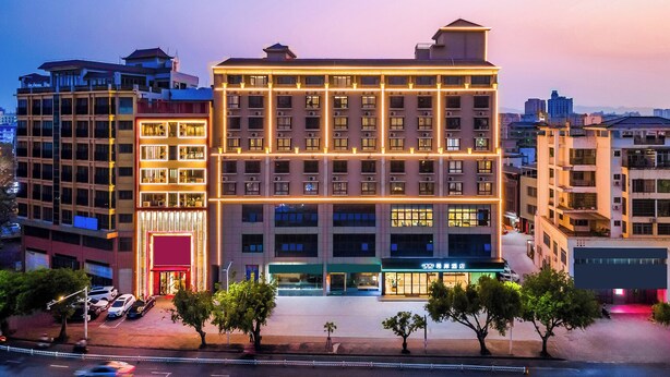 A multi-story hotel with a central atrium, multiple floors, and a ground-level restaurant. - xana Hotel  (Qionghai)