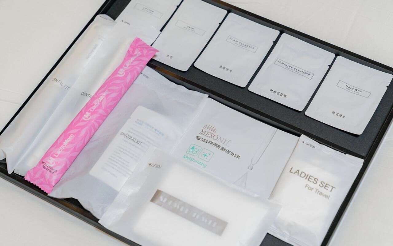 Une trousse de toilette de voyage avec des compartiments étiquetés pour différents produits d’hygiène personnelle.