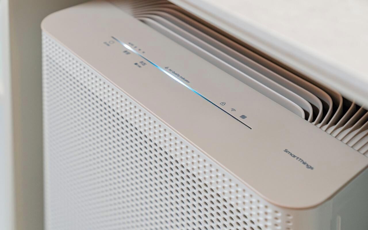 A white, modern air purifier with a control panel and a SmartThings logo.