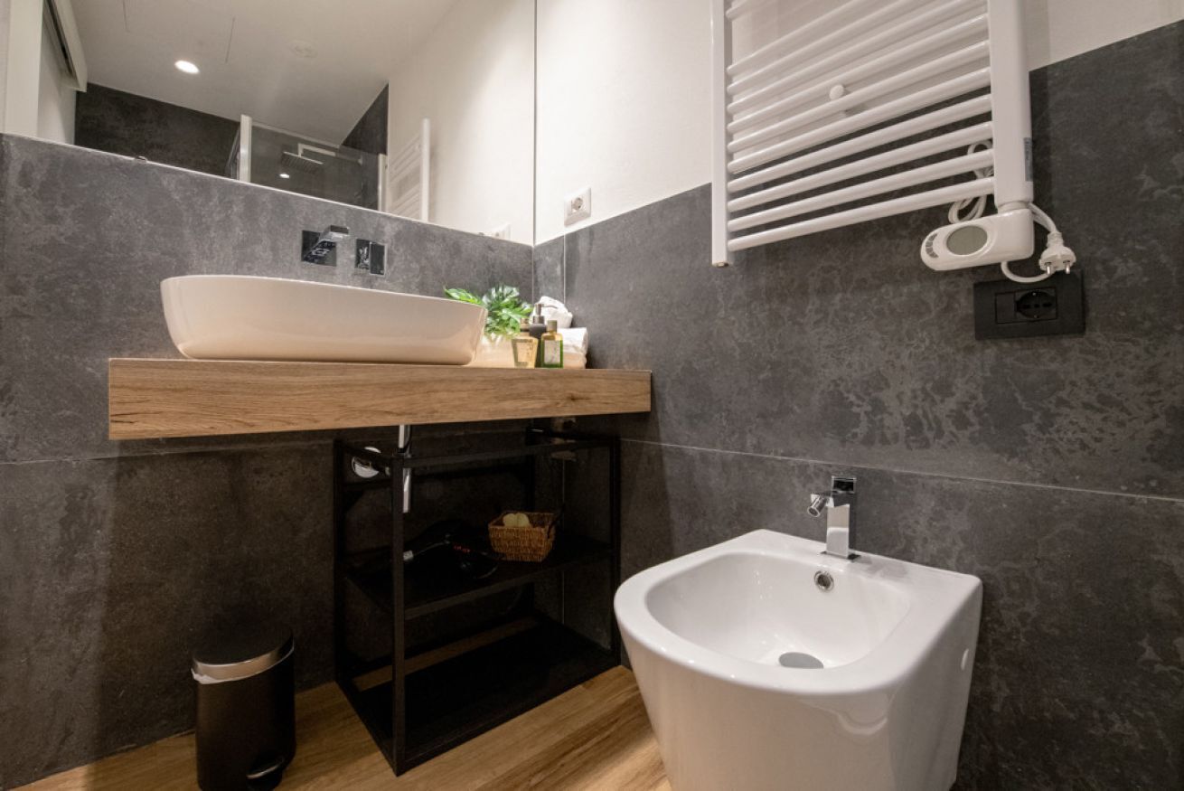 Ein modernes Badezimmer mit einem Aufsatzwaschbecken, einem Bidet und einem Spiegel über dem Waschbecken.