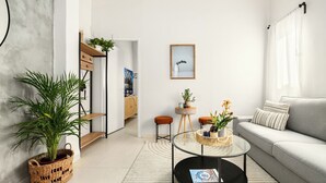 A modern living room with a sofa, coffee table, and potted plants. - Florentin Stylish Stay by Sea N' Rent (Tel Aviv)