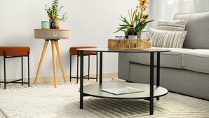 A modern living room with a round coffee table, two chairs, a sofa, and a small side table with plants and a basket. - Florentin Stylish Stay by Sea N' Rent (Tel Aviv)