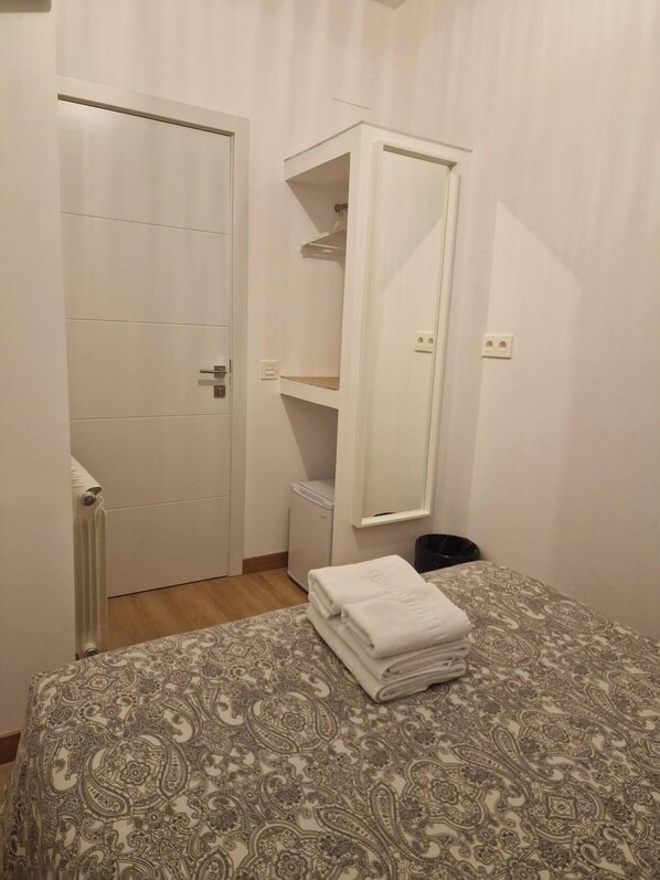 Une chambre à coucher avec un lit, une armoire et un radiateur.