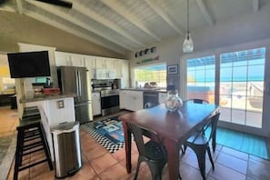 Modern kitchen with stainless steel appliances, white cabinetry, and a large window offering a view of the outdoors.