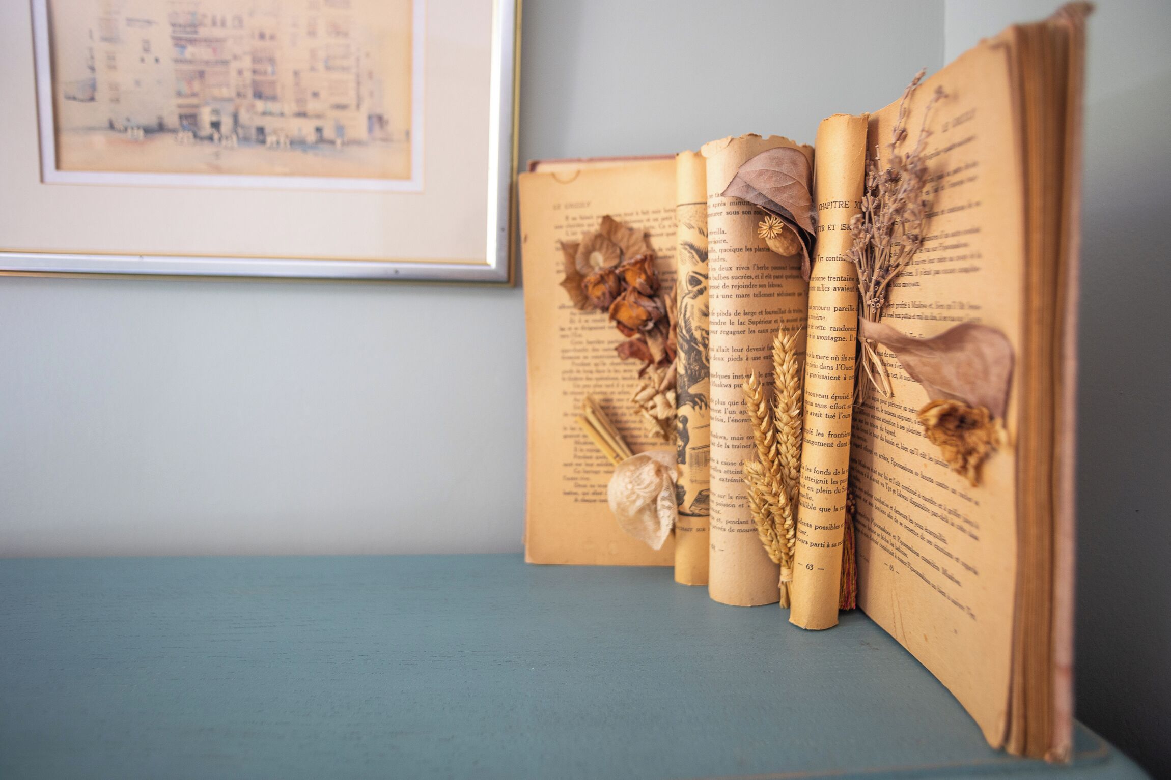Un libro abierto con páginas visibles, decorado con flores y hojas secas.