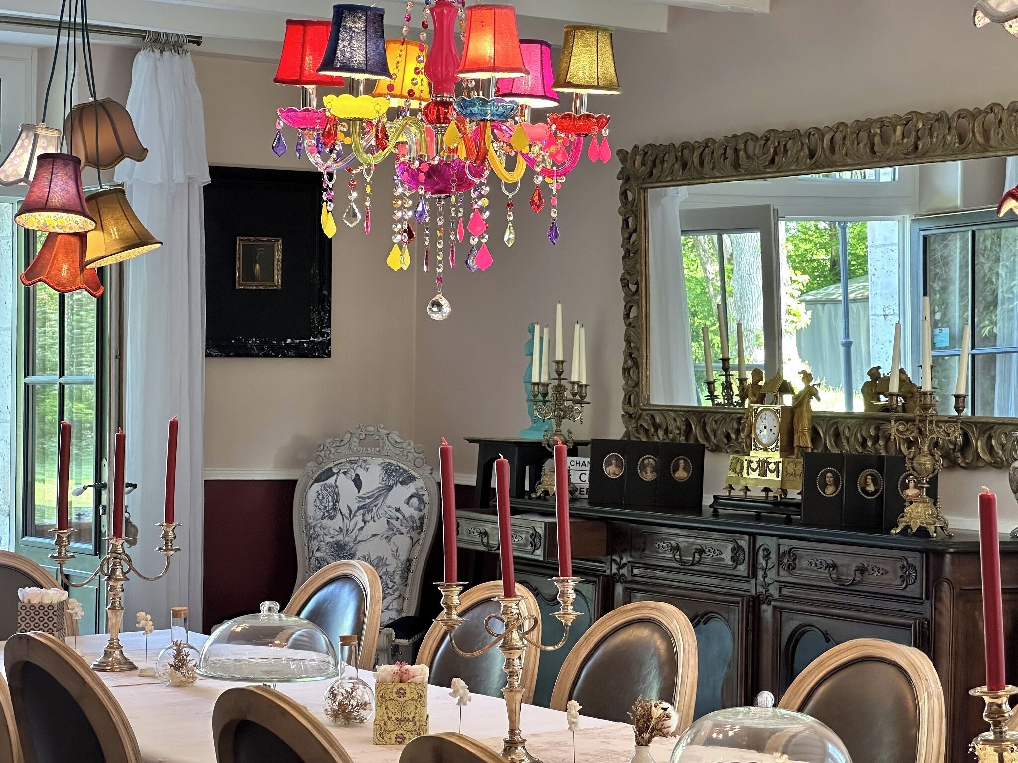 Un comedor con candelabro, velas y muebles de estilo elegante.