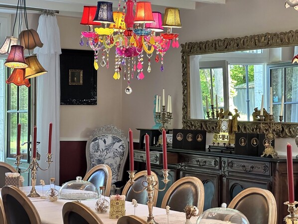 A dining area with a chandelier, candles, and ornate furniture. - MANOIR LE COUTUREAU (Rouffignac-de-Sigoulès)