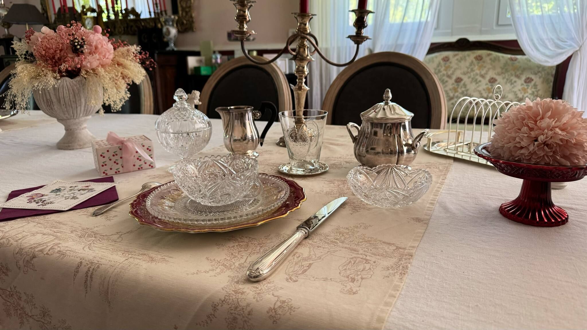 A table set with fine china, silverware, and glassware, suggesting a formal dining setting.
