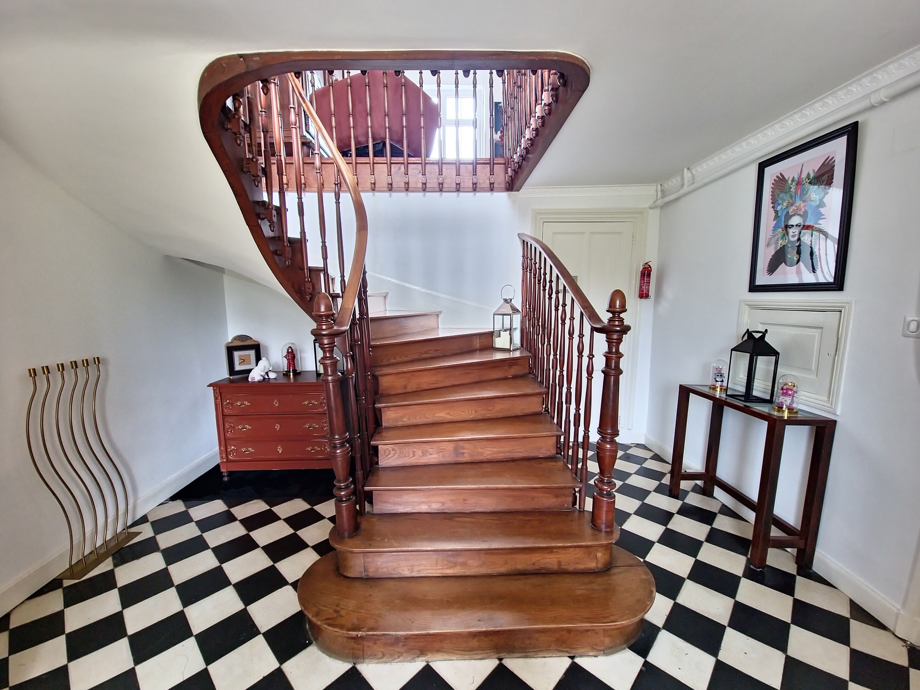A wooden staircase with a checkered floor and a spiral design.