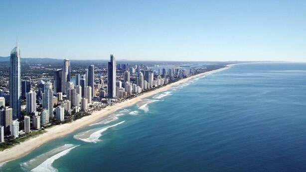 A coastal cityscape with high-rise buildings along a beach.