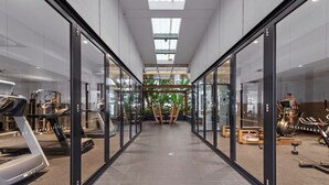 A modern gym with glass walls, treadmills, and exercise equipment.