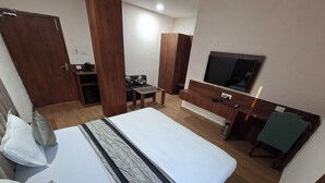 Ένα δωμάτιο ξενοδοχείου με ένα μεγάλο κρεβάτι, μια τηλεόραση, ένα γραφείο και μια ντουλάπα.