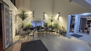 A spacious indoor area with multiple seating arrangements, potted plants, and a modern design. - The Chilling'N Homestay (Hanoi)