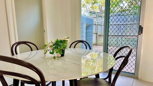 Un comedor con una mesa redonda, cuatro sillas y una planta en maceta.