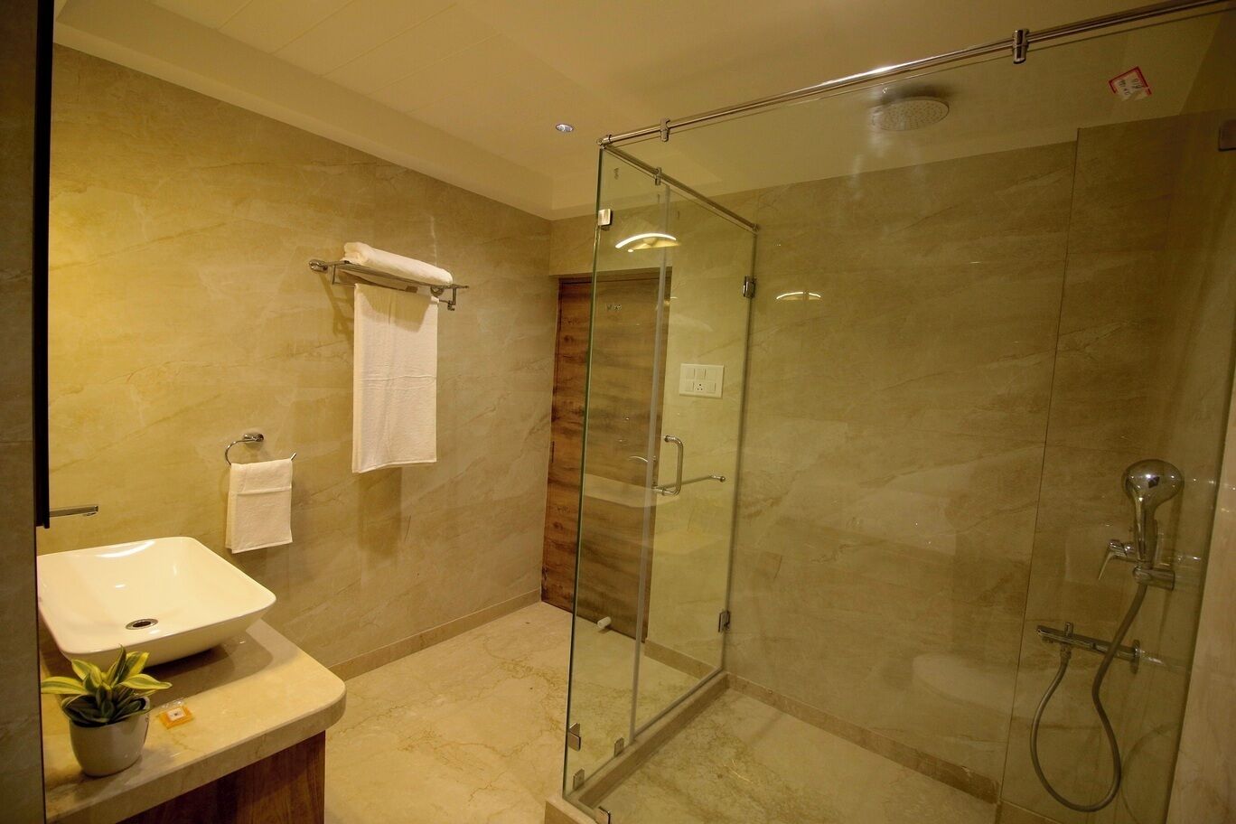 Een moderne badkamer met een douchecabine van glas, een wastafel en een handdoekrek.