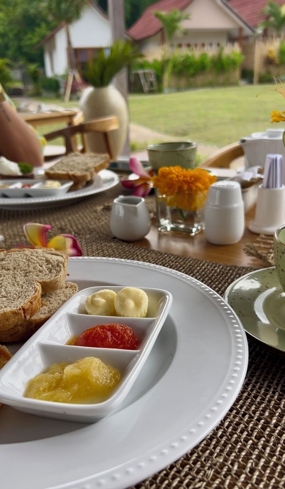 Una escena de desayuno con una rebanada de tostada, mantequilla, mermelada y confitura.