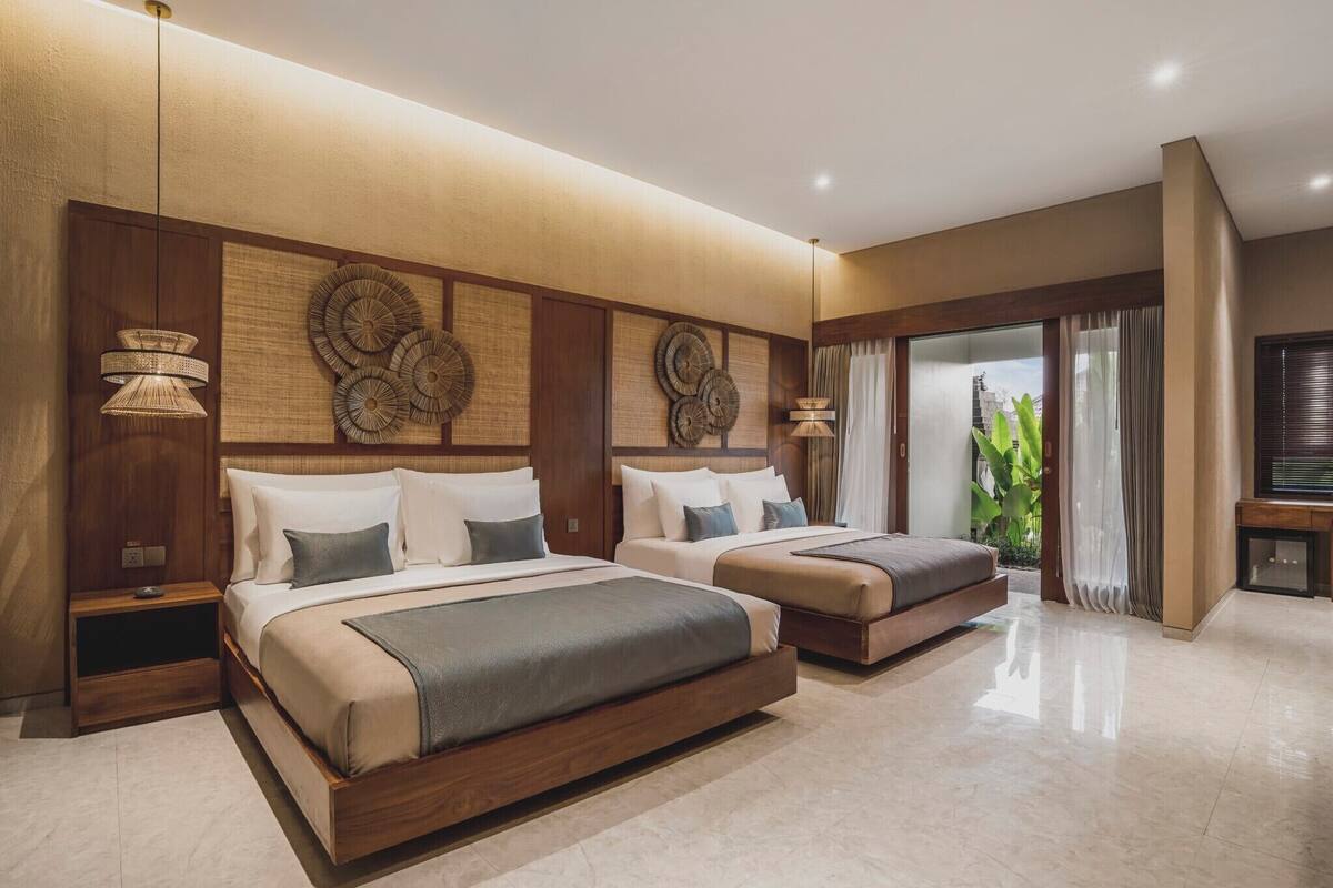 A modern hotel room with two beds, a large wall art piece, and a view of the city.