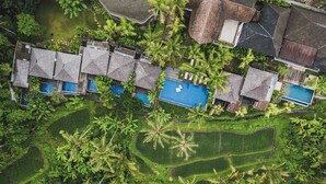 An aerial view of a resort with multiple bungalow-style buildings, a swimming pool, and lush tropical vegetation. - Maar Resort Ubud by Ini Vie Hospitality (Payangan)