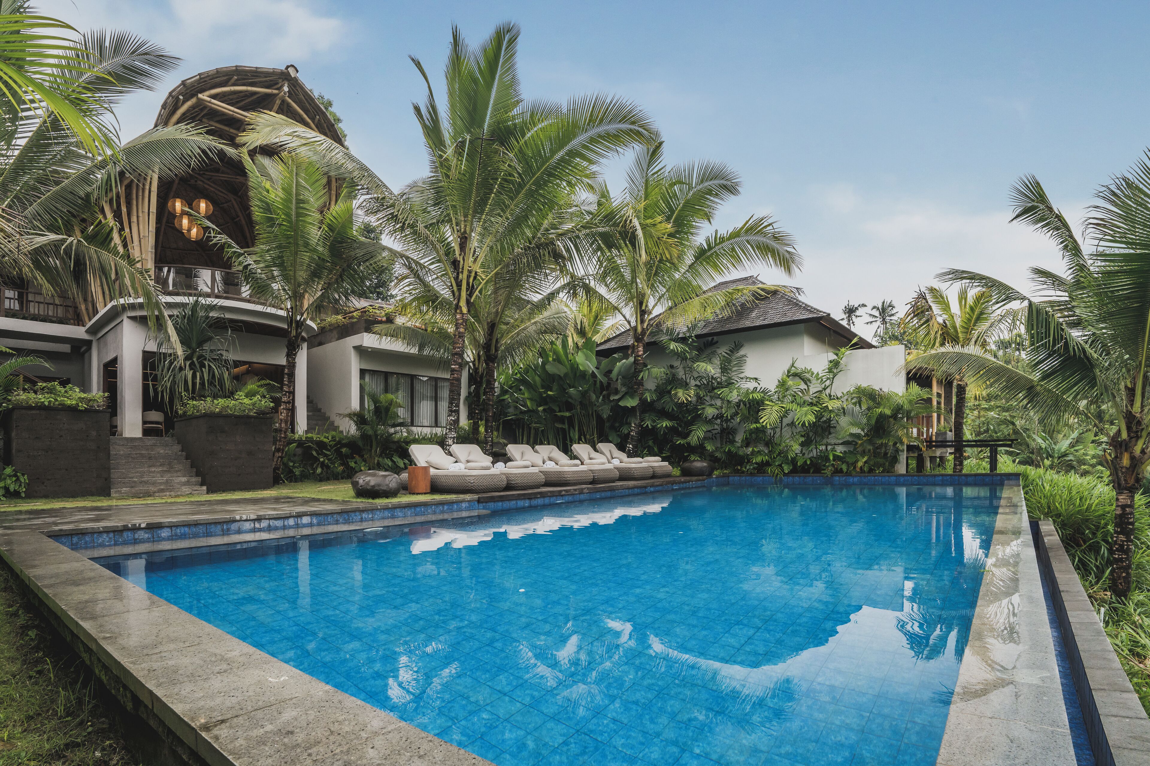 Una piscina al aire libre, sillones reclinables de piscina