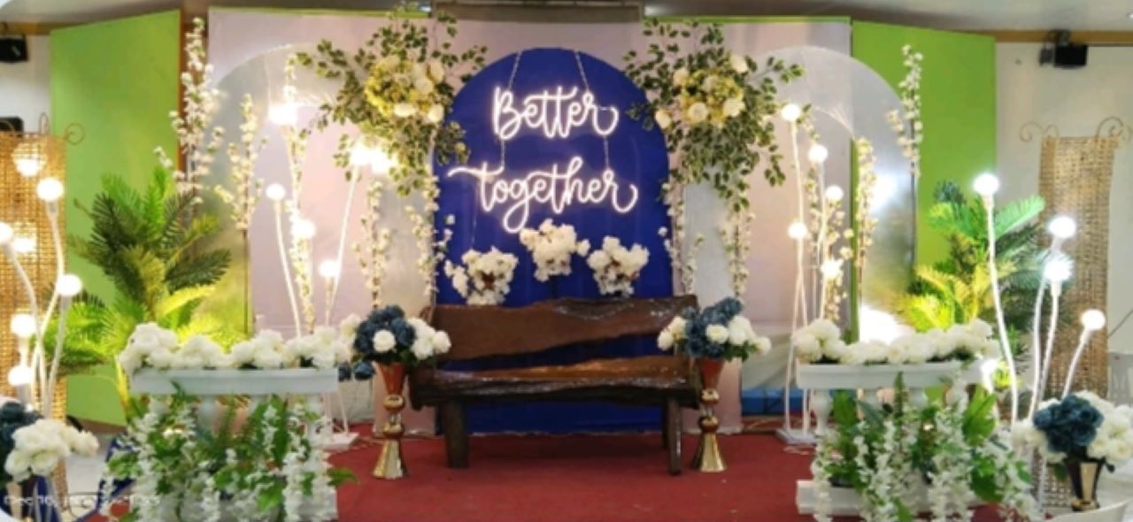 Une scène avec un banc, des décorations florales et une pancarte sur laquelle on peut lire : « Ensemble, c’est mieux ».