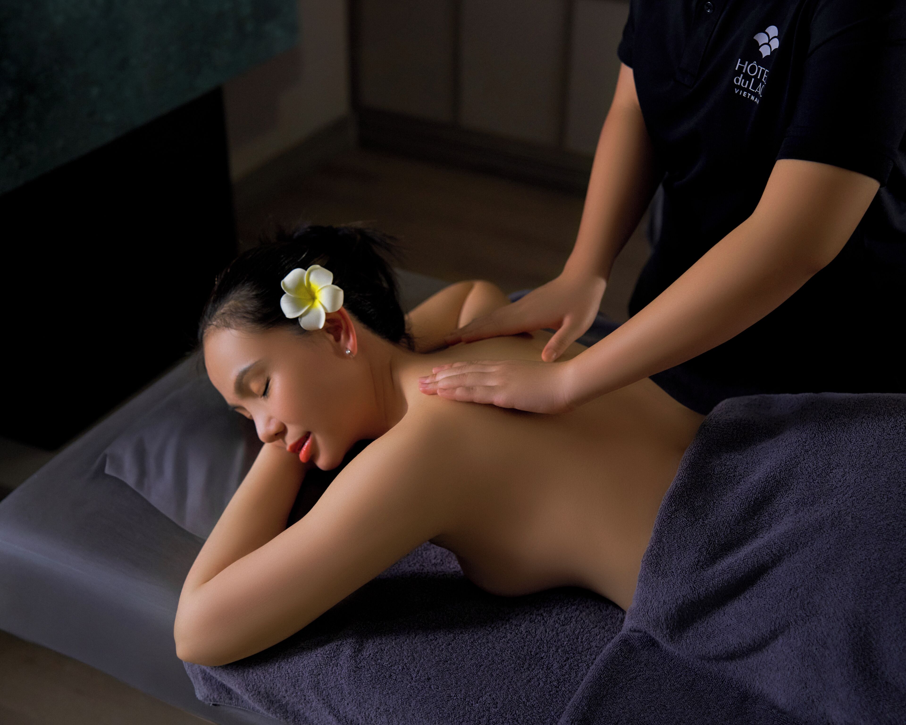 A massage therapy session in a spa setting with a massage therapist attending to a client.