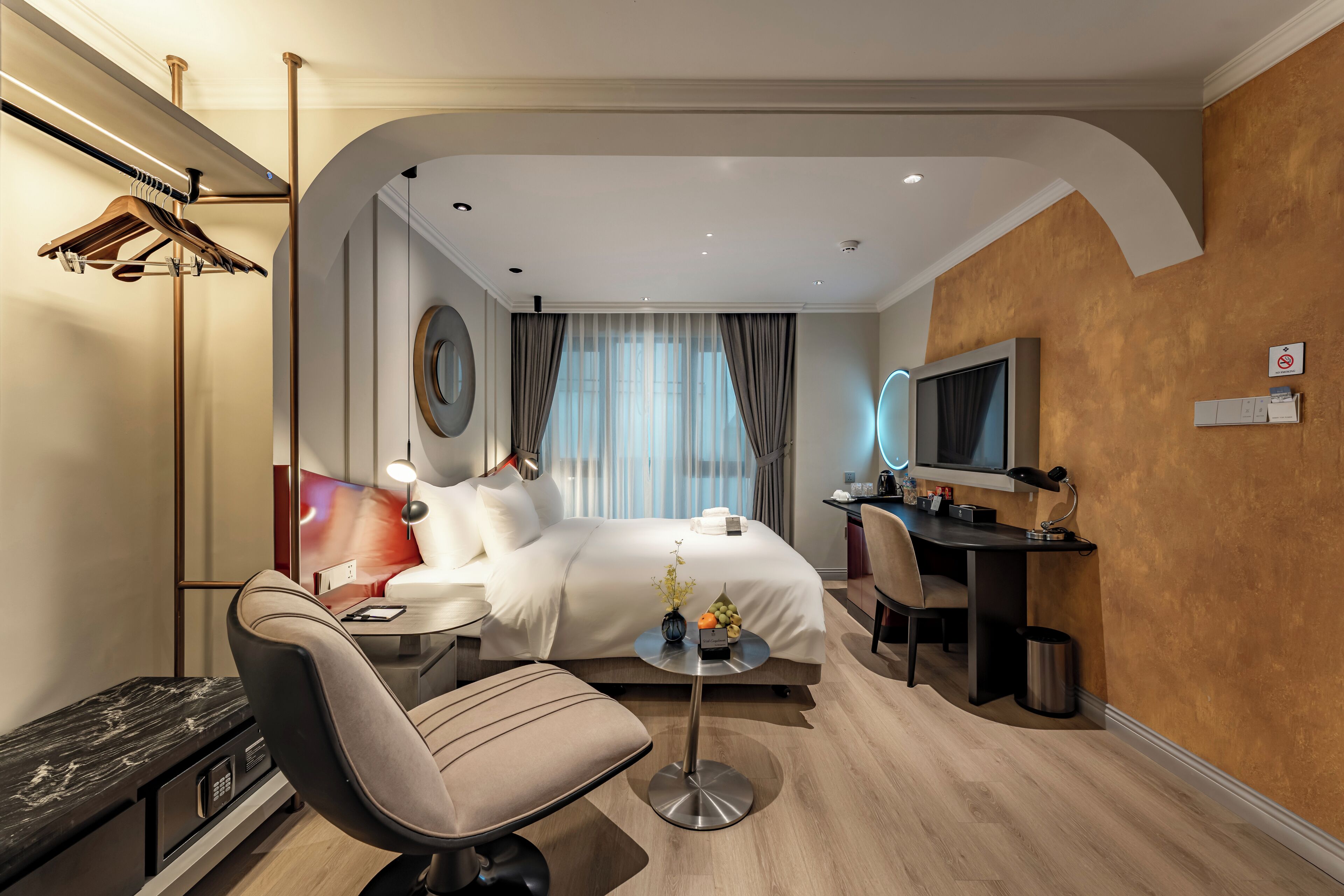 Camera d'albergo moderna con letto, scrivania, sedia e televisore.