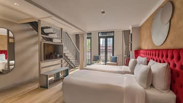 A hotel room with a large bed, a red upholstered headboard, a TV, a staircase, and a view of the outside.