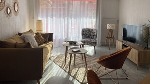 A modern living room with a sofa, armchairs, a coffee table, and a TV. - Superb bright apartment, terraces free secure parking 600m from the sea (Cagnes-sur-Mer)