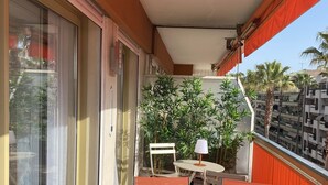 A balcony with a table set for breakfast, including plates, cups, and a bottle. - Superb bright apartment, terraces free secure parking 600m from the sea (Cagnes-sur-Mer)