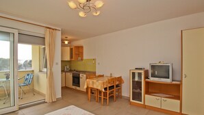 A compact living space with a dining area, kitchenette, and a television. - Charming studio Ljubica (Punat)