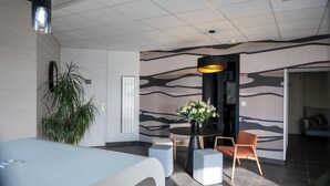 Ein modernes Interieur mit Essbereich, einer Topfpflanze und einer Wand mit Muster.