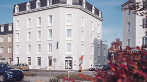 Ein mehrstöckiges Hotel mit weißer Fassade, zahlreichen Fenstern und einem sichtbaren Eingang.