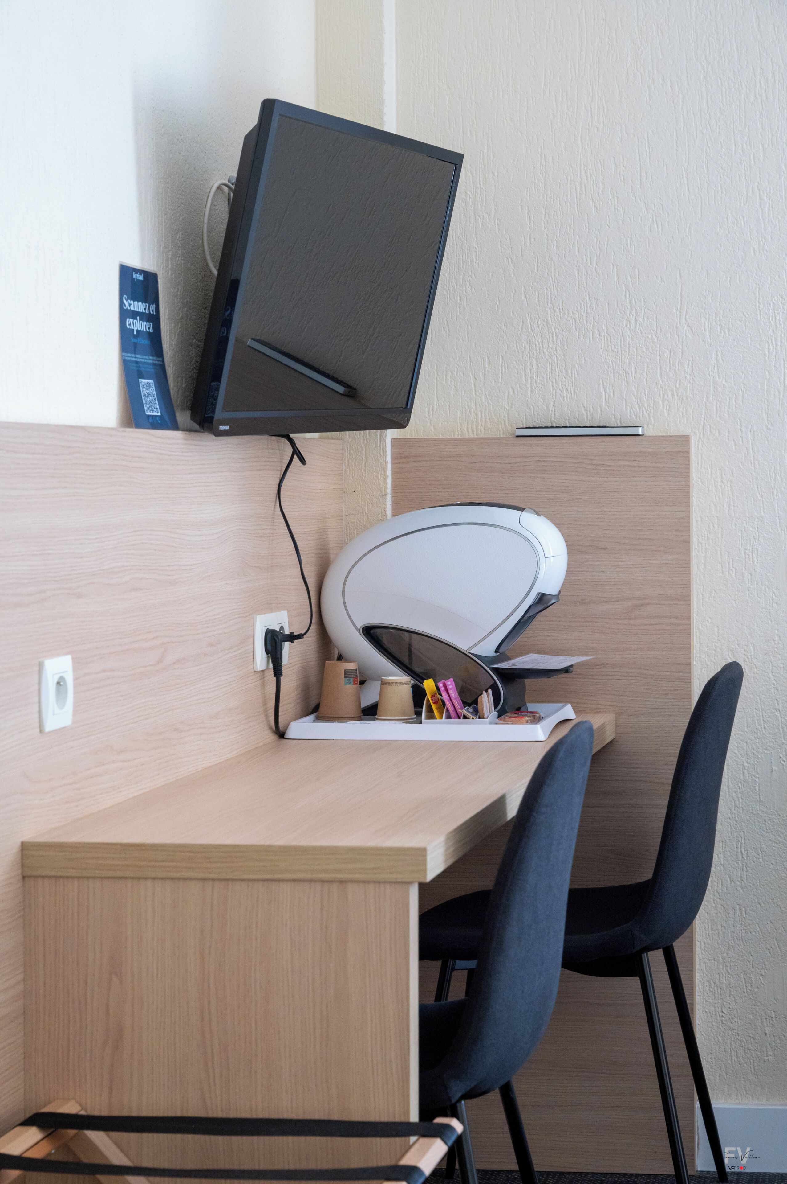 Een bureau met een computer, een printer en twee stoelen.