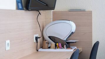 Een bureau met een computer, een printer en twee stoelen.
