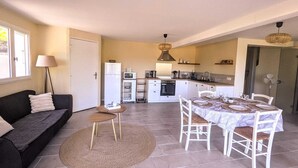 A compact living space with a kitchenette, a dining area, and a sofa.