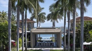 Un moderno resort con un patio central, palmeras y vista al océano.