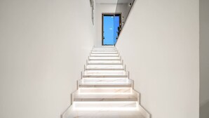 A staircase with white marble steps leading to a blue door. - Peaceful 4BR Villa in Jumeirah Golf Estates with Garden Views (Jumeirah Golf Estate)
