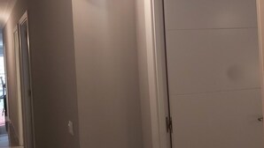A hallway with a white door and a light fixture on the wall. - Spacious Family Apartment in Málaga, near historic center (Málaga)