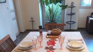 A dining table set with plates, glasses, and autumn leaves. - Chambres d'hôtes Au Bord De Loire (La Marche)