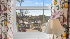 A room with a window view of an outdoor area, including a playground and buildings.